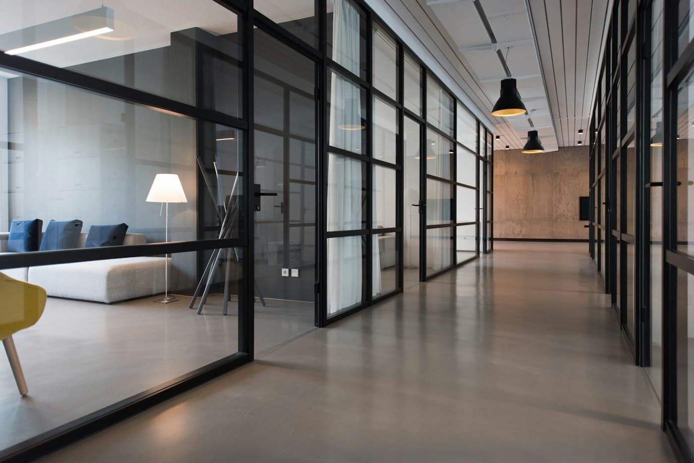 Quiet professional office corridor with glass meeting rooms