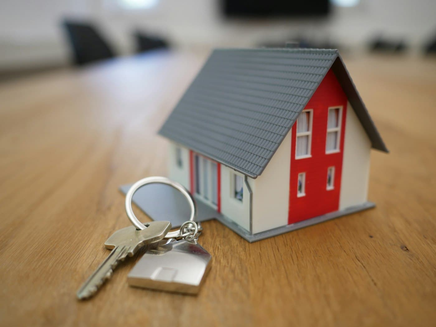 House keys and a small model property on a wooden table