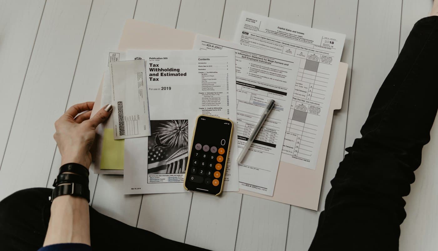 Property tax forms, envelopes, and a calculator arranged on a dark desk