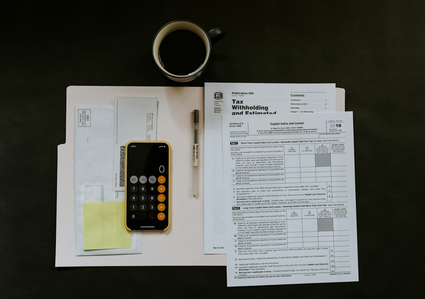 Estate tax forms and schedules arranged on a desk for comparison